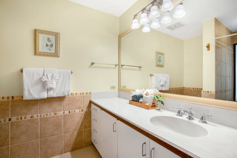 A crisp white double-sink vanity pairs beautifully with warm terracotta tiles, offering comfort and everyday refinement
