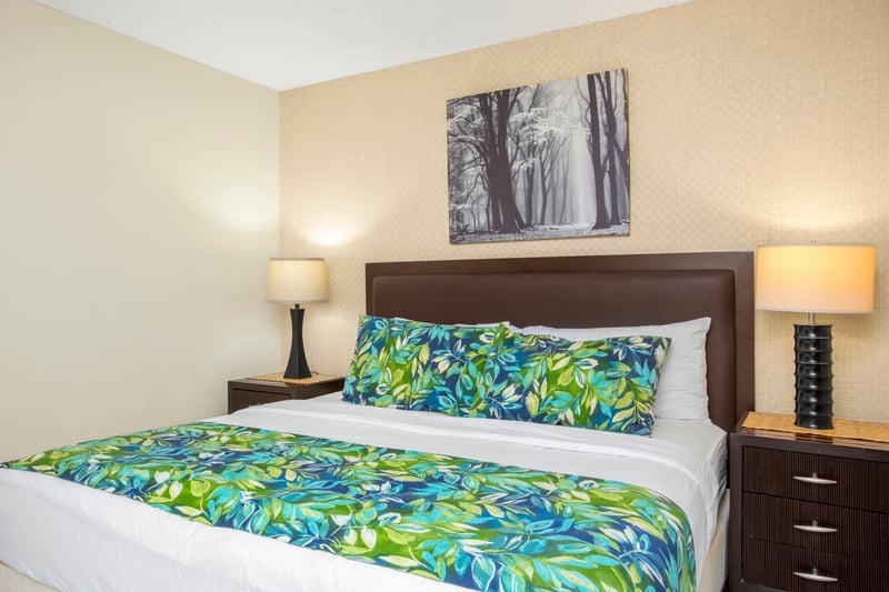 Tropical blooms meet city chic—this guest room pairs bold bedding, lanai light, and sleek storage with a smile