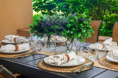 Gather around this beautifully dressed lanai table, set amid tropical greenery and the comfort of shaded elegance
