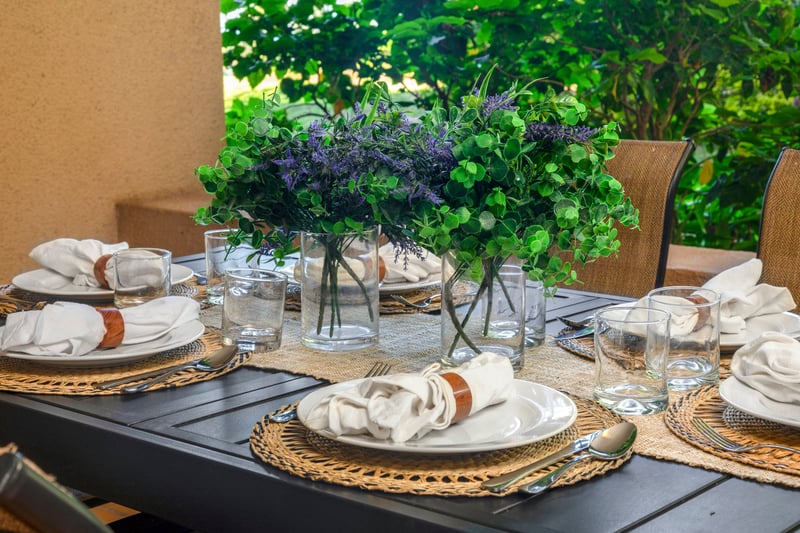 Gather around this beautifully dressed lanai table, set amid tropical greenery and the comfort of shaded elegance