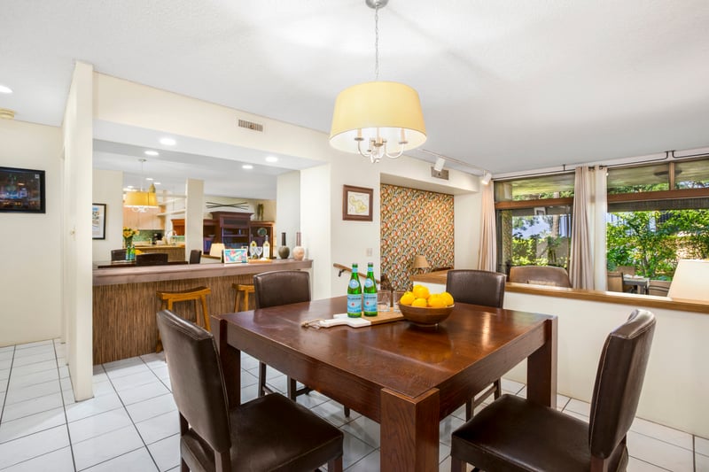 Tucked beneath a cheerful pendant and framed by garden views, this dining spot invites connection and easy joy