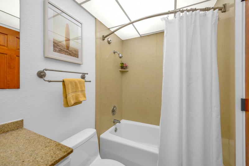 The guest bathroom features a tub to unwind in after a day exploring the island
