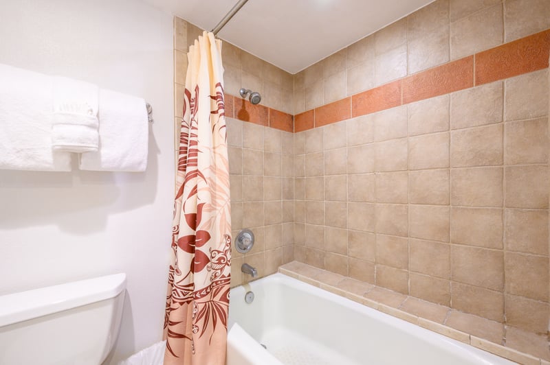 Clad in sun-washed tile with a terracotta accent band, the tub-shower combo evokes warmth and classic island simplicity KS-258