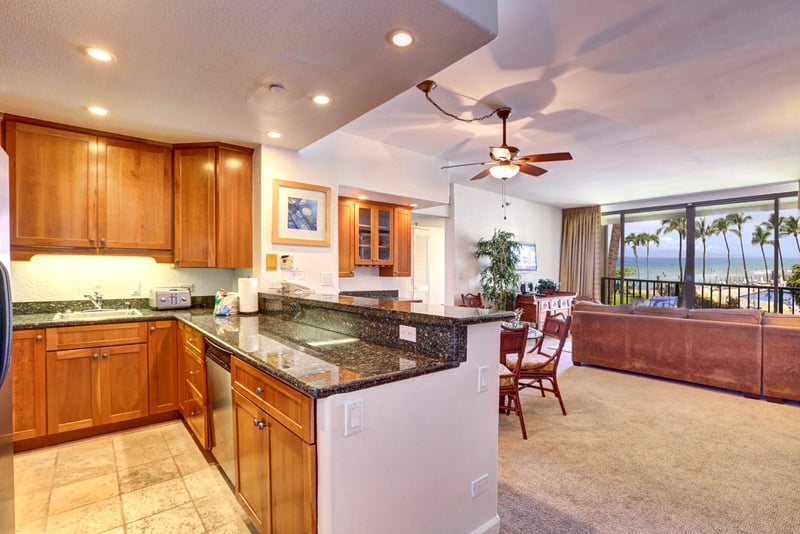 Granite glows, cabinets gleam, and fans spin softly—this warm kitchen is ready for flavors, stories, and sunshine KS-258