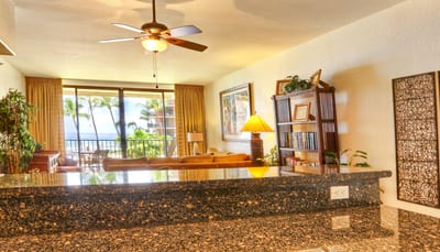 Chop, stir, and sip in a kitchen kissed by palm views, amber cabinets, and glossy granite that steals the spotlight