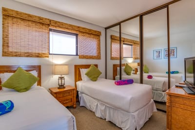 Mirrored wardrobe, twin beds, and a touch of tiki charm—plus a breezy lanai to greet each island morning