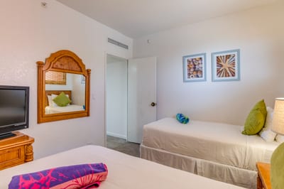 A playful twin retreat with mirrored charm, pops of color, lanai breezes, and a closet that’s ready for aloha