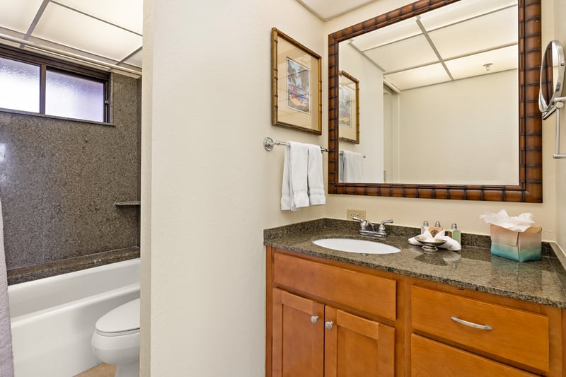 A bamboo-framed mirror adds tropical flair, reflecting clean lines and curated amenities that welcome with thoughtful ease KS-535