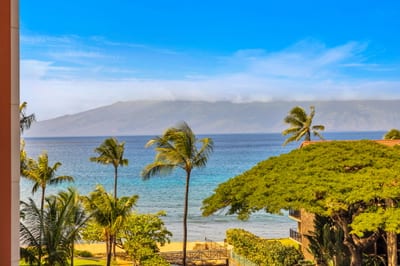 Just steps from the sand, this elevated view showcases Maui’s lush coastline and the calm, blue waters of the Pacific.