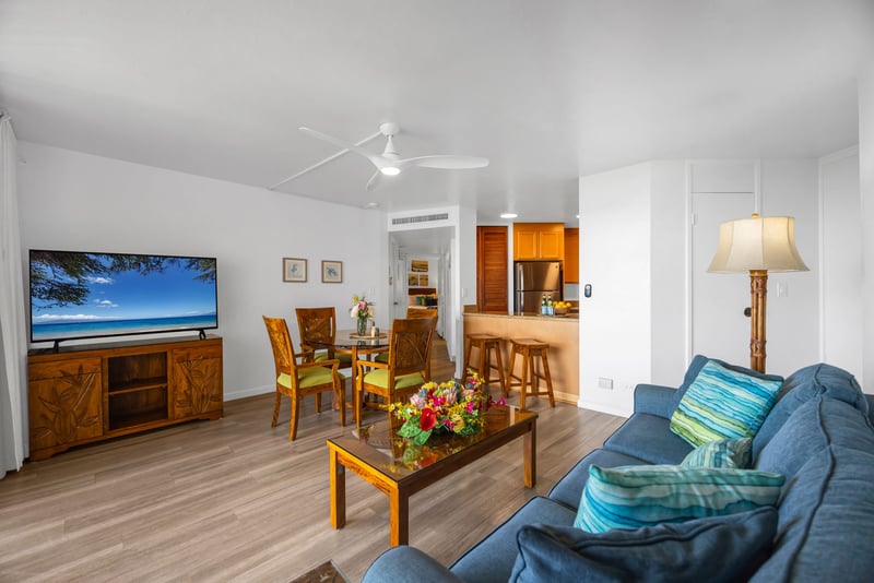 Spacious open layout with island-inspired furnishings, a large Smart TV, and breakfast bar seating just off the fully equipped kitchen.