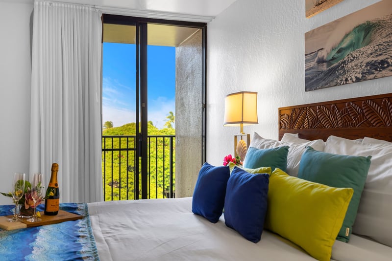 King bedroom with direct lanai access and lush treetop views, perfect for quiet mornings or a celebratory evening toast.