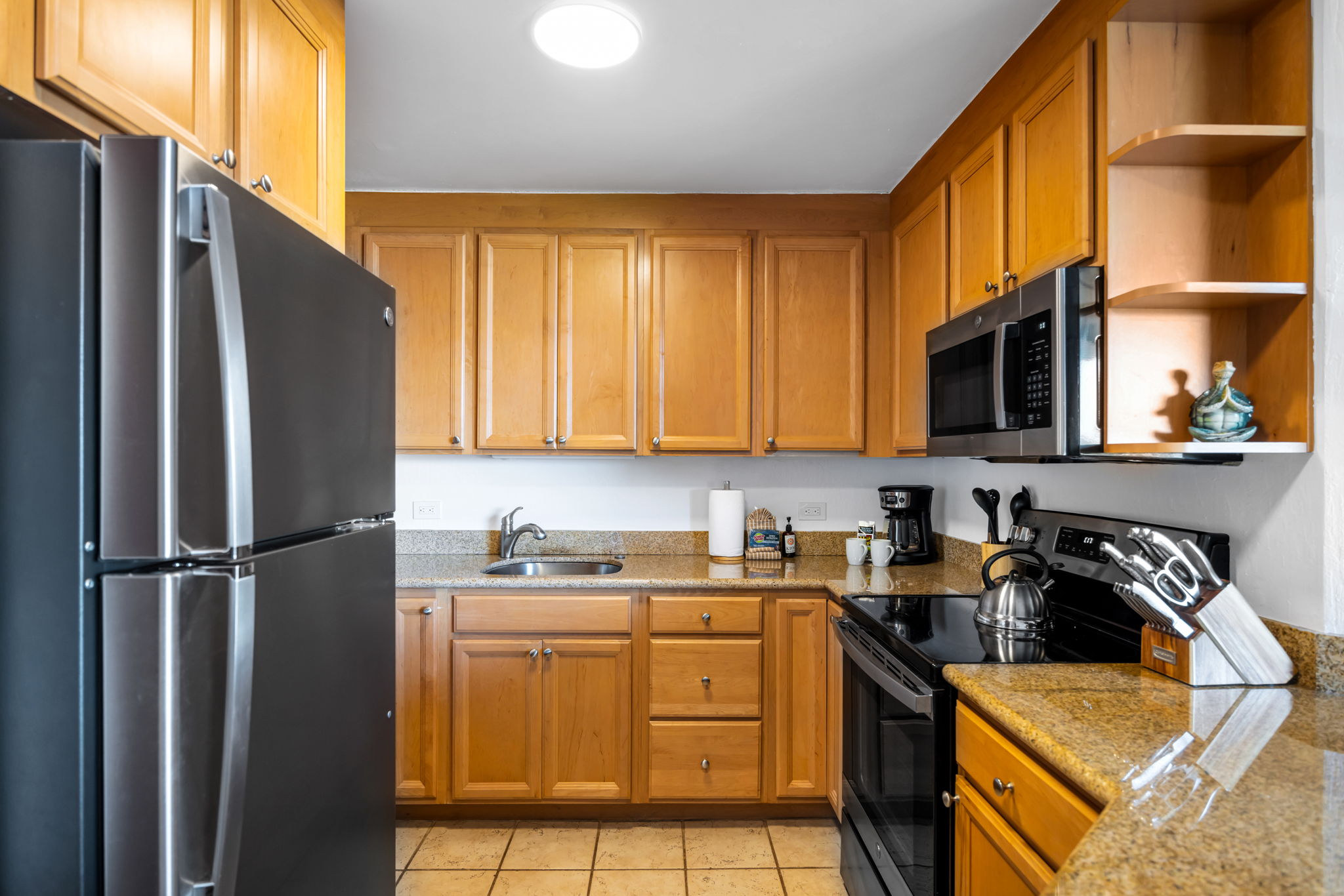 This fully equipped kitchen features granite countertops, full-size appliances, and ample cabinetry for easy vacation meal prep. KS-616