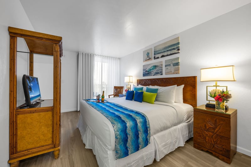 Spacious King bedroom with island-inspired decor, a flat-screen TV, and soft lighting for a restful night’s sleep.