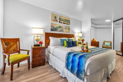 Well-appointed King bedroom with tropical wood accents, mirrored closet, and soft lighting for a restful retreat after sun-soaked island days.