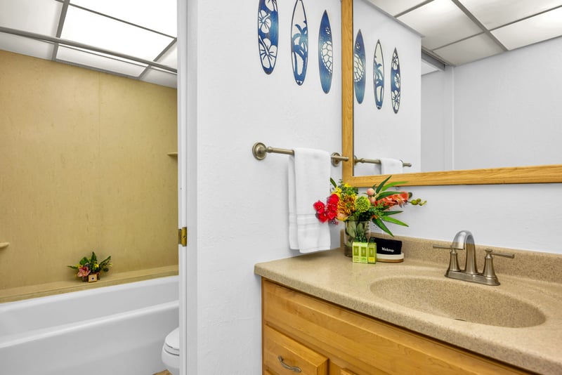 Bathroom with a tub-shower combo, single-sink vanity, and cheerful floral touches for a bright and functional refresh.