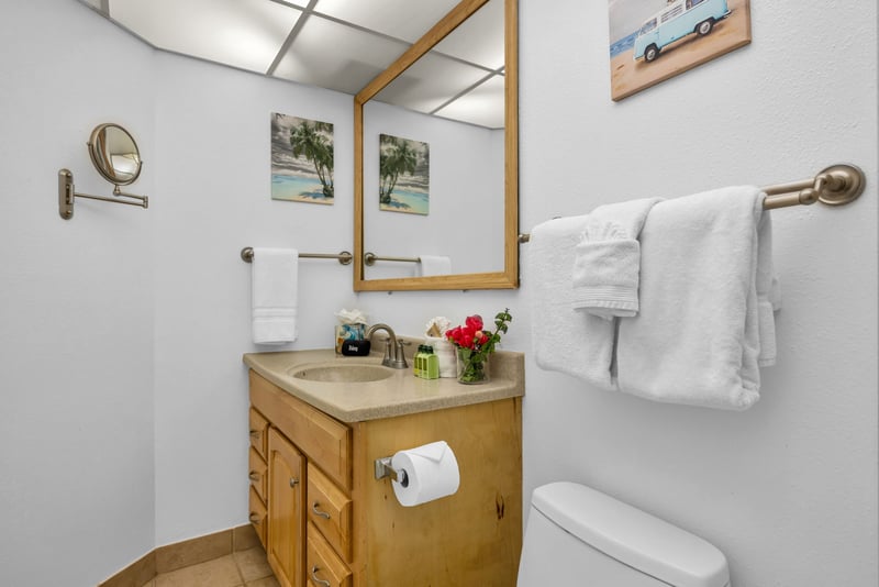 Guest bathroom with a single-sink vanity, large mirror, and fresh island details for a clean and comfortable daily routine.