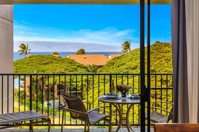 Framed by floor-to-ceiling glass, this lanai invites you to dine with views of the Pacific and lush canopy below.