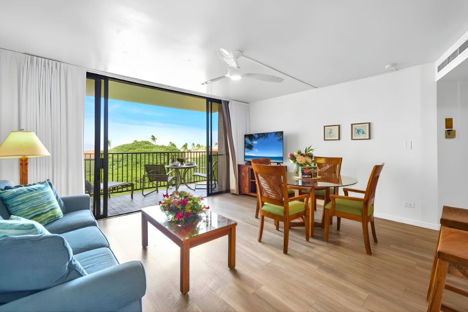 Open-concept living and dining area with direct lanai access and a large Smart TV, perfect for relaxed nights after a day on the beach. KS-616