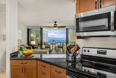 With rich wood tones and granite gleam, this cozy kitchen invites you to whisk, stir, and toast in tropical style