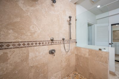 This spa-inspired bath features a soaking tub, rainfall shower, and stunning travertine tile surround KBV-12B3