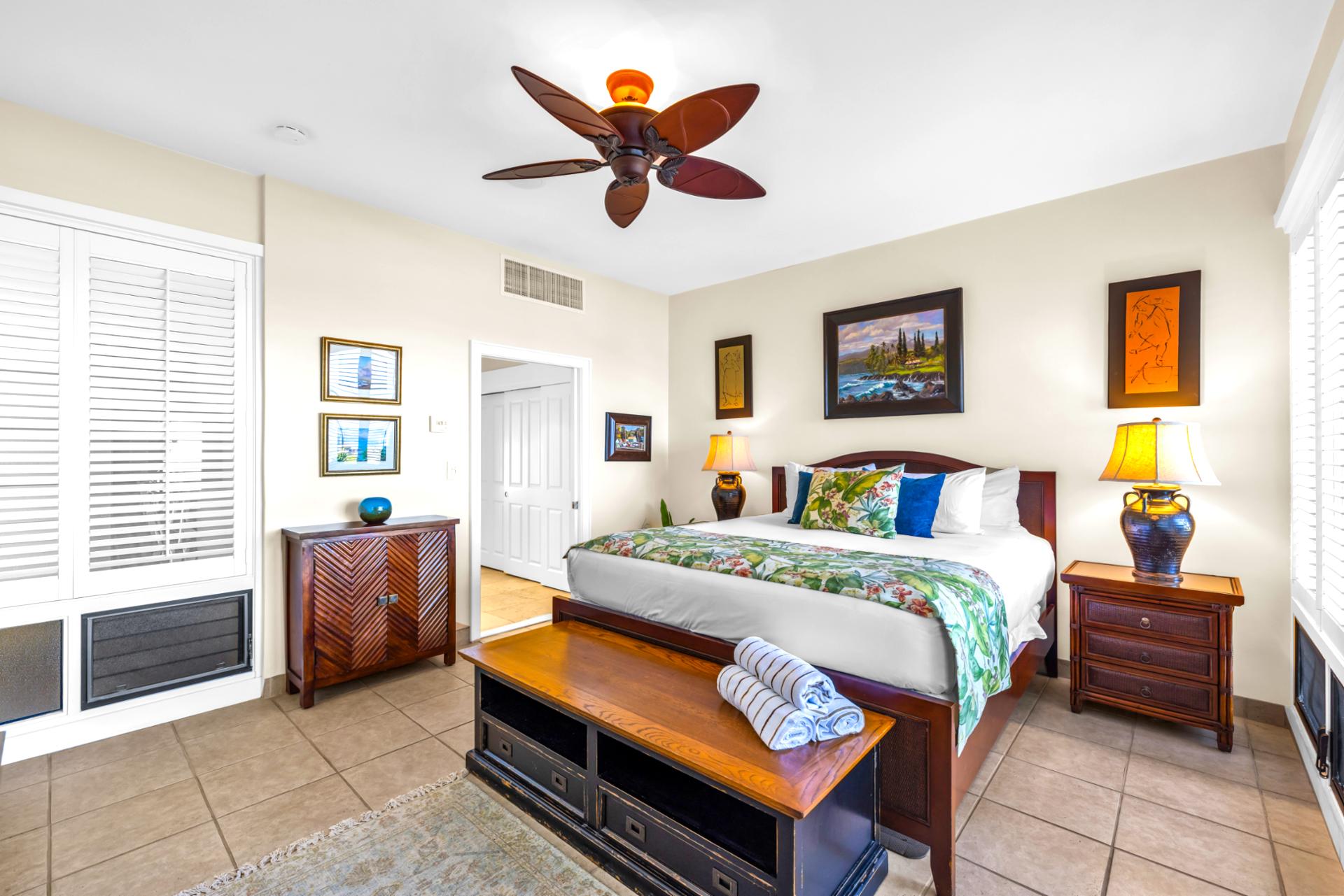 The primary bedroom features a king size bed and tasteful island inspired decor