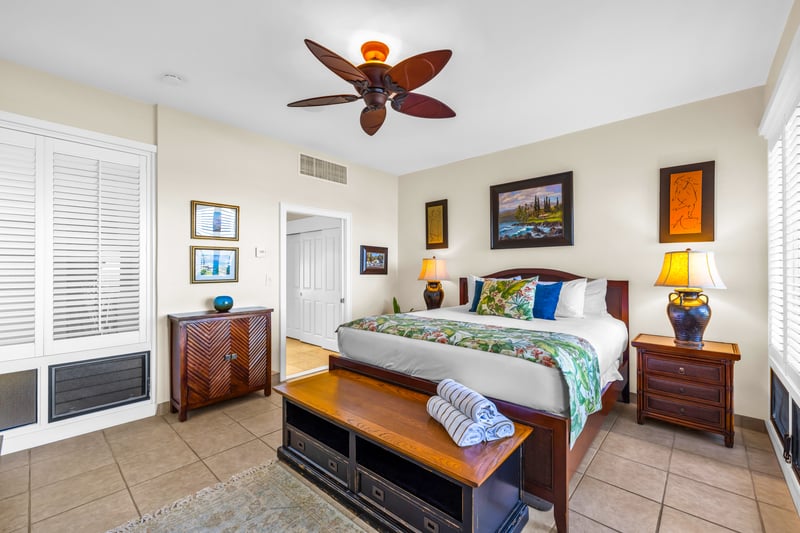 The primary bedroom features a king size bed and tasteful island inspired decor