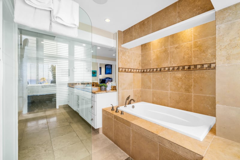 The guest bathroom features an updated glass walk in shower and separate soaking tub for ultimate relaxation