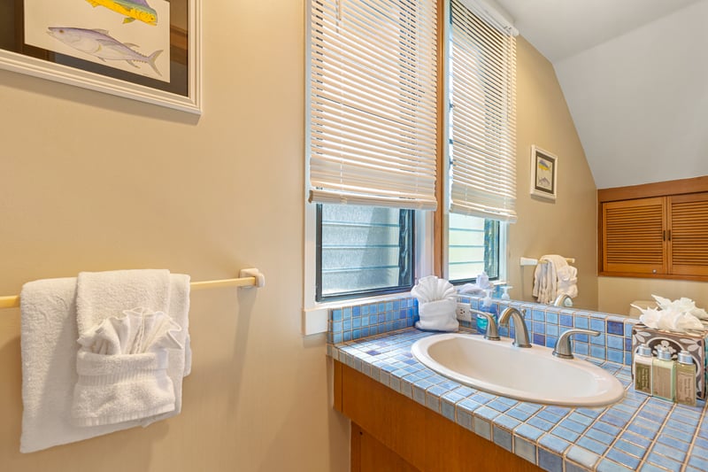 Designed for calm, this light-filled space pairs warm tile tones with fresh finishes and coastal flair