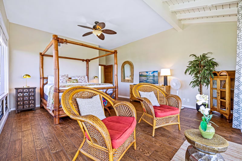 Elegant oceanview master retreat with a four-poster king bed and sunlit moments framed by palm trees     