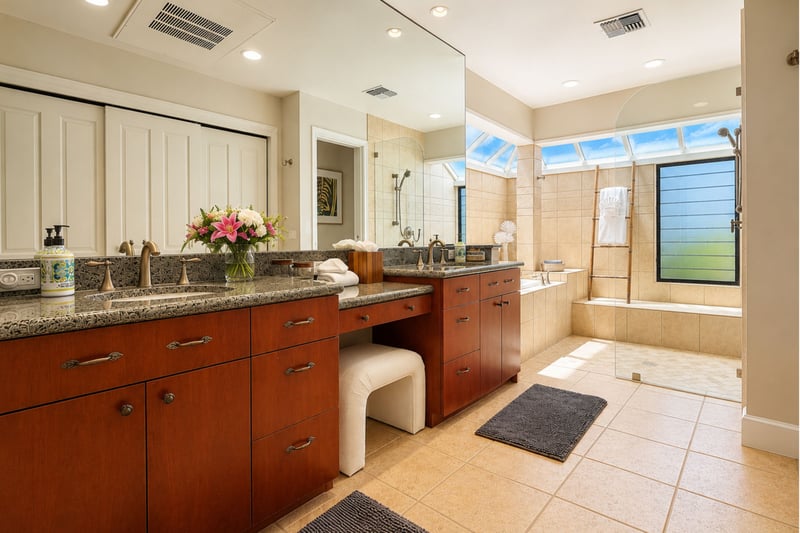 A vanity stool sits between the dual sinks in your primary bathroom, with the soaking tub and glass shower just beyond.