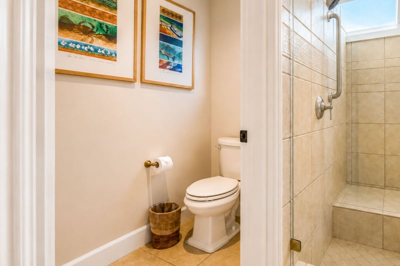 A private toilet room off your primary bathroom sits beside the walk-in shower, with local artwork adding a personal touch.