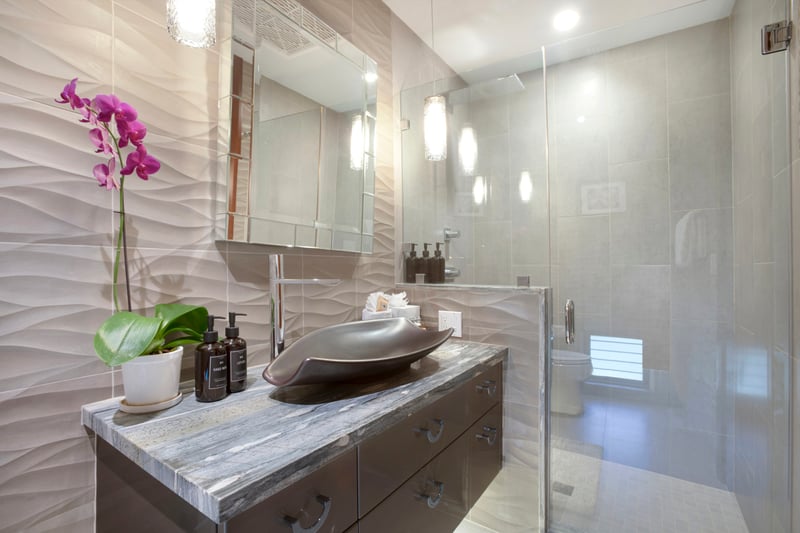 This dazzling master bath is a marble dream—sparkling white tile, orchids, and a spa shower built for luxury and light
