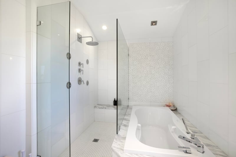 From sleek glass showers to marble vanities and blooming orchids, this bath is beauty, comfort, and calm all in one