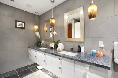 Get ready in style under amber lights, surrounded by stone elegance and a shower that feels like a private waterfall retreat