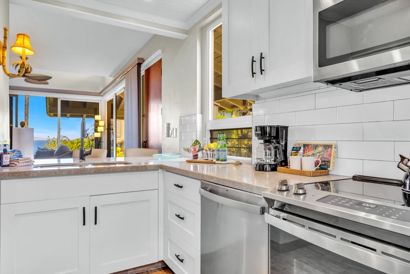 Bright kitchen with modern appliances, bar seating, and surrounded by windows with island views.  KBV-24G3