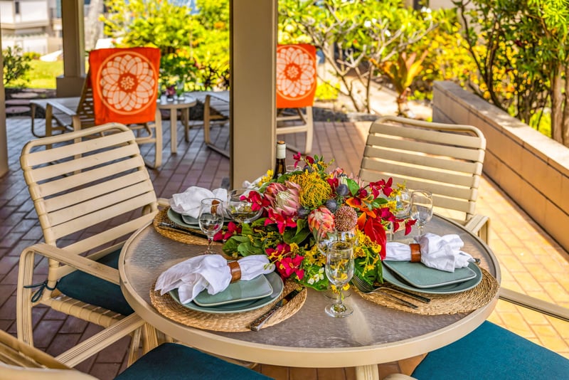 Covered outdoor dining area surrounded by tropical greenery, perfect for enjoying meals or drinks with a refreshing breeze. KBV-24G3