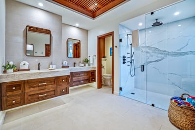 Luxurious spa-style bathroom with dual vanities and rainfall shower.