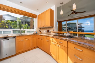 Start your mornings in a bright, open kitchen surrounded by sunlight, tropical views, and modern stainless steel charm KBV-28G2