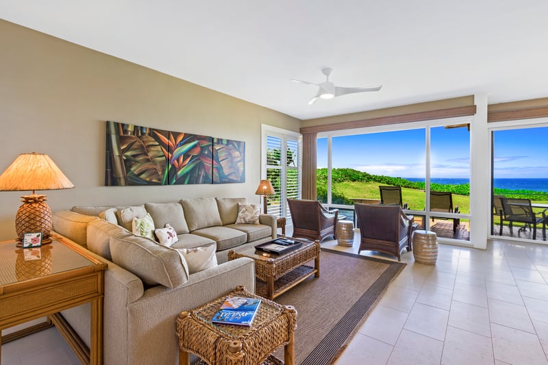 Relax in a sunlit living room with plush seating and panoramic views of lush green and ocean blue KBV-30G2