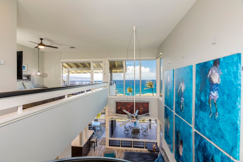 Dive into comfort beneath bold aquatic artwork and a statement staircase in this truly unforgettable lounge