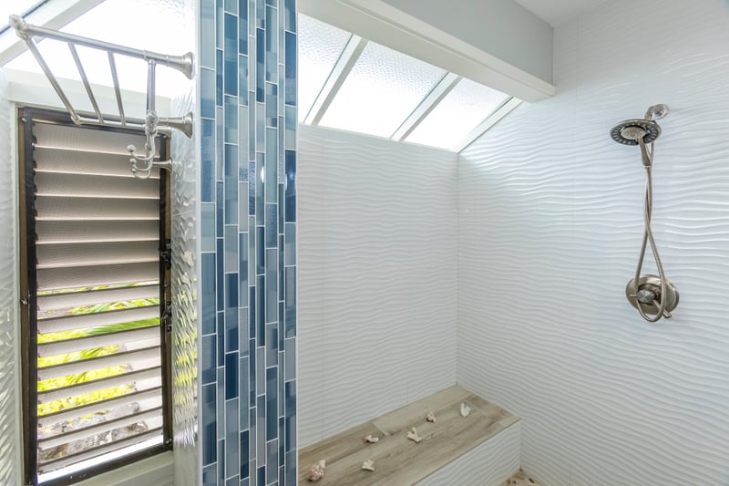 The walk-in stone shower, warm wood accents, and natural light make this master bath a guest favorite