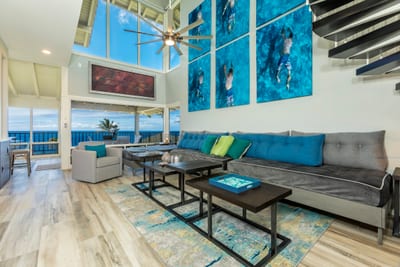 Soak in breathtaking ocean views from this designer living room with soaring ceilings and wall-to-wall glass