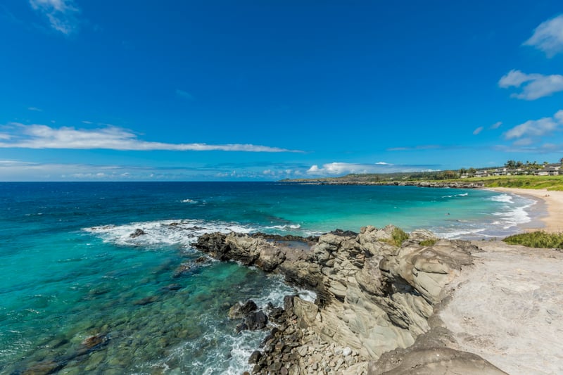 Where golden sands curl along turquoise waves and lava rock juts proudly into the glistening Pacific horizon