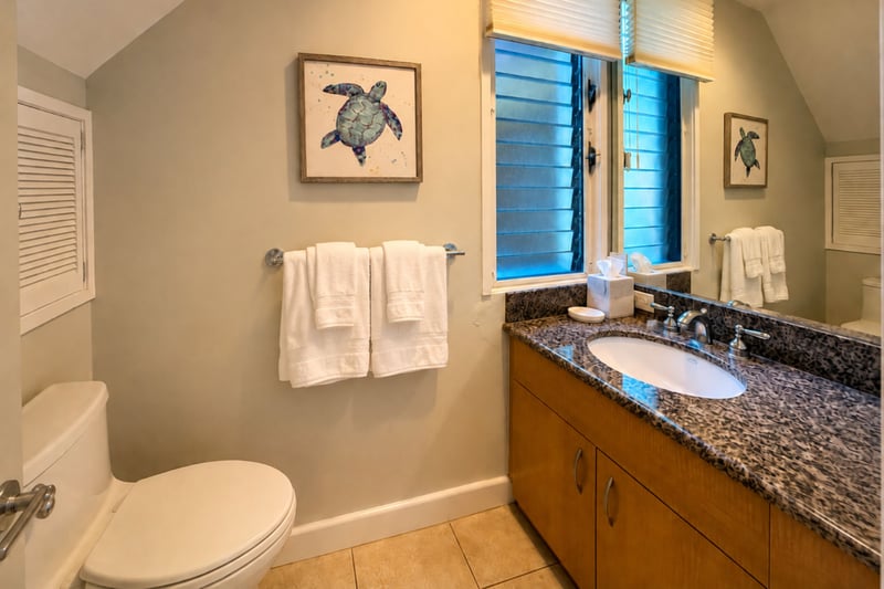 Your guest half bath features a spacious vanity and granite counter, conveniently located on the entry level.