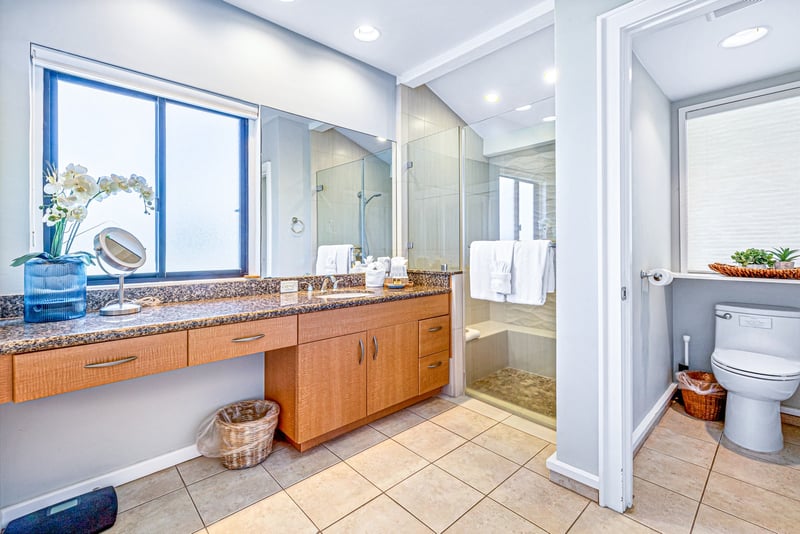 Your spacious bathroom vanity provides generous counter space and storage, with a bright window adding natural light.