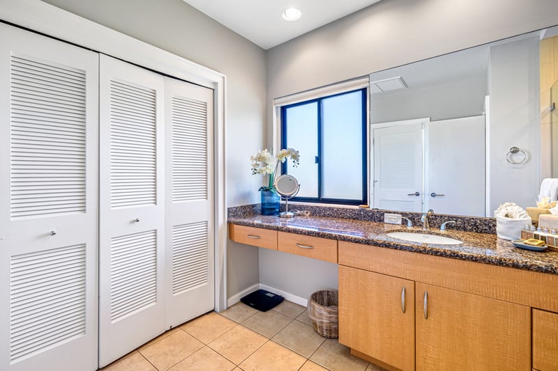 Get ready comfortably at your long vanity, with abundant counter space, cabinetry, and a large mirror.