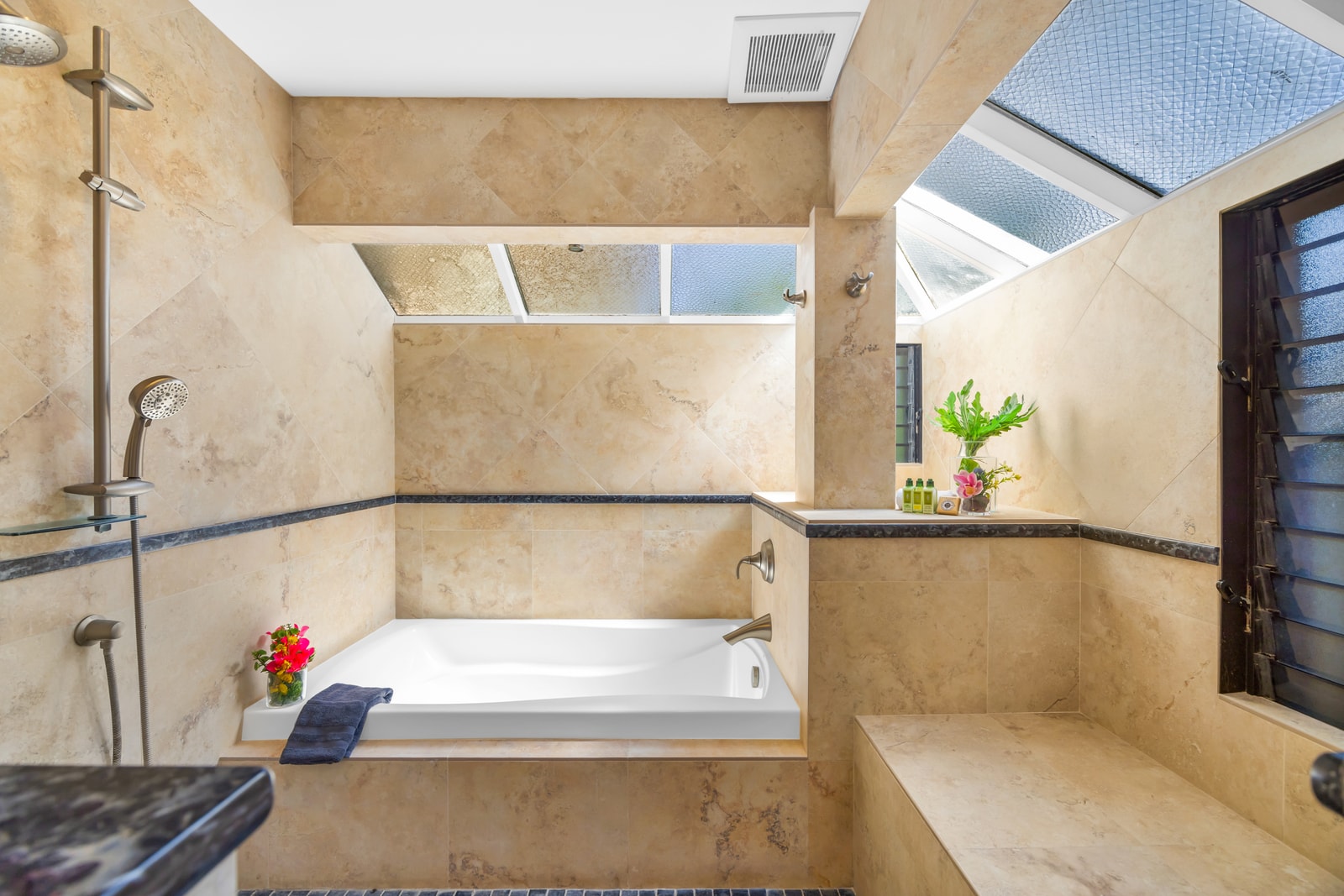 Spacious walk-in shower with glass doors adds comfort and ease after beach adventures.