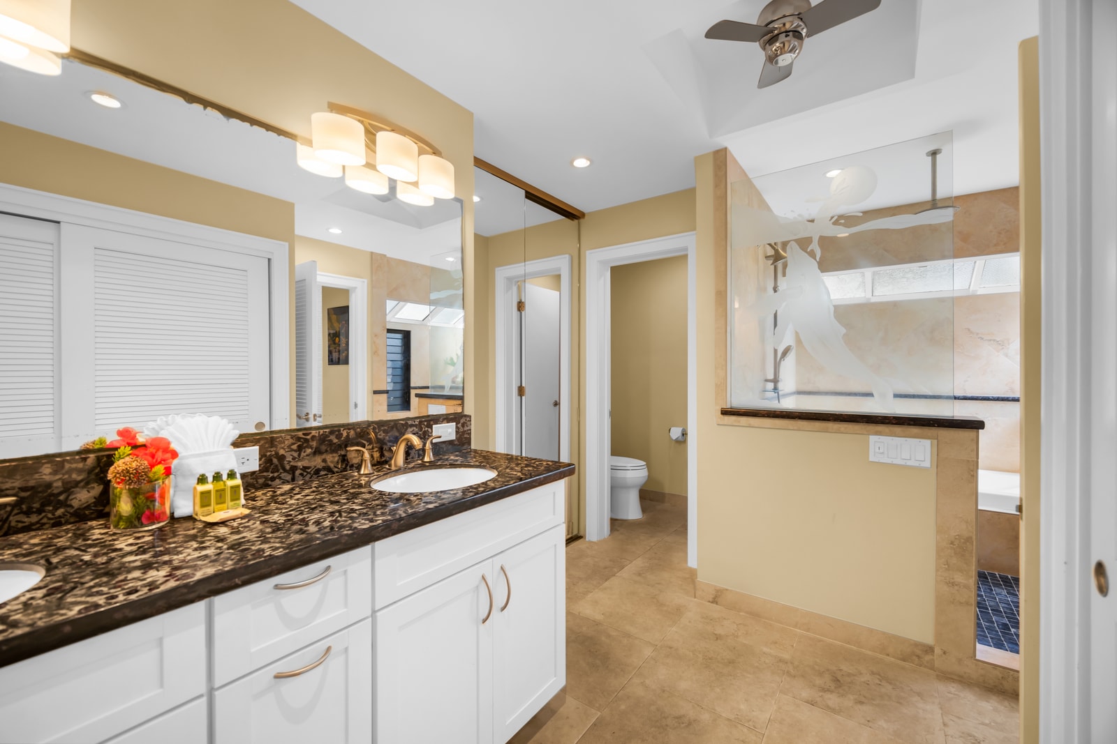 The en-suite bathroom offers granite counters and plenty of space to refresh.