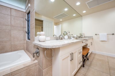 Spacious and refined, this bathroom includes a luxurious tub, expansive mirrors, and a serene ambiance