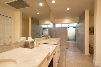Relax and unwind in this elegant bathroom featuring a deep soaking tub, dual vanity, and soft natural lighting